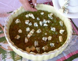 disposition des dés de fromage sur la tarte et les raisins