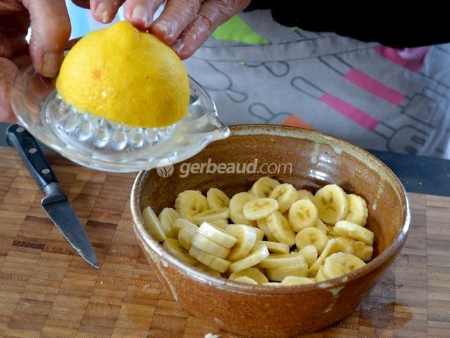 Arrosage des rondelles de banane avec un jus de citron