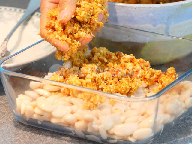 Disposition du crumble sur les haricots tarbais cuits