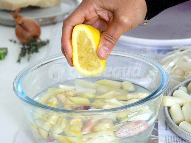 Trempage des pointes d'asperges dans l'eau citronnée