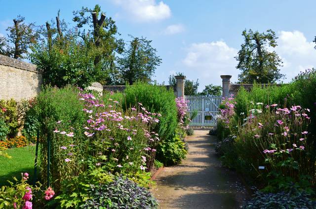 Allée bordée de fleurs dans un jardin normand