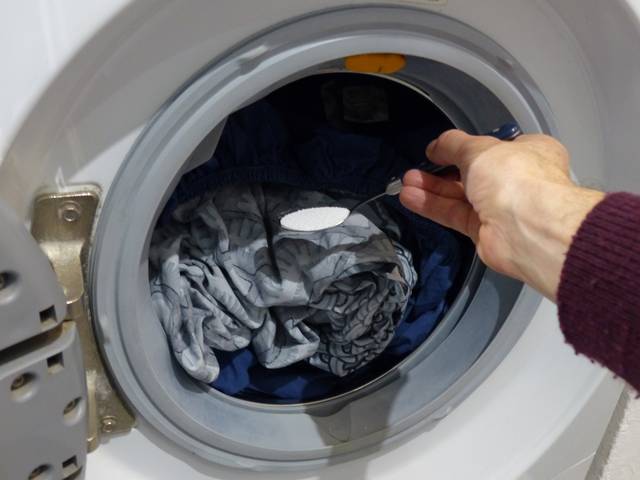 Ajout d'une cuillère à soupe de percarbonate dans le lave-linge