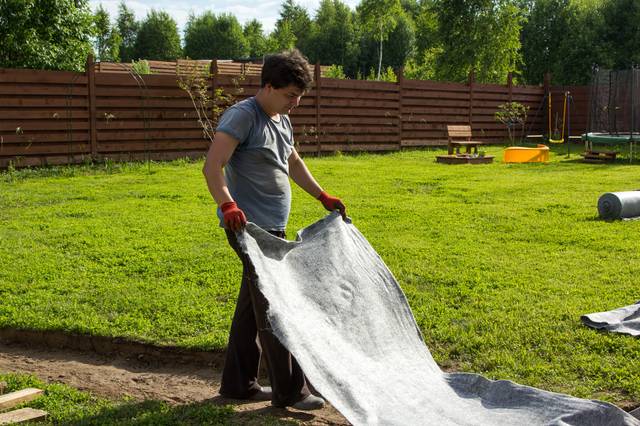 Pose d'un géotextile dans la partie creusée du sol