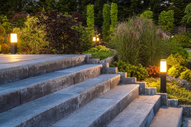 Eclairage décoratif par bornes lumineuses d'un escalier de jardin en béton