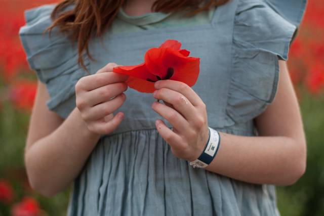Jeune fille avec un coquelicot dans les mains