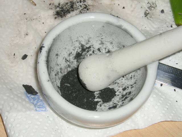 Broyage de charbon de bois au mortier
